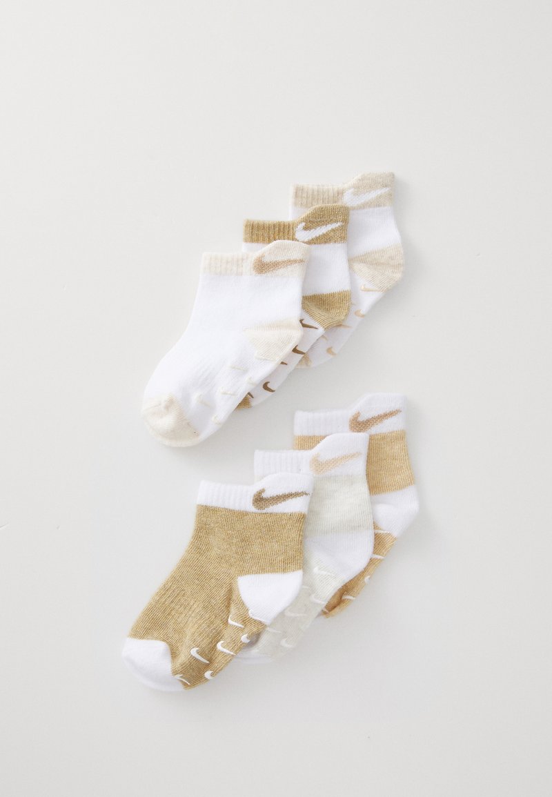 Conjunto de seis pares de calcetines cortos con colores blanco y dorado claro, con puños acanalados y pequeños logos de Nike en los laterales.