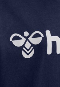 Un tessuto blu scuro presenta un design grafico bianco di un'ape stilizzata e della lettera "h". La texture è liscia e la stampa è audace.