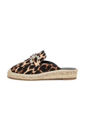 Des chaussures à enfiler en imprimé léopard avec une semelle en jute tressé, présentant une boucle décorative ornée de pierres transparentes et un dessus en tissu lisse.
