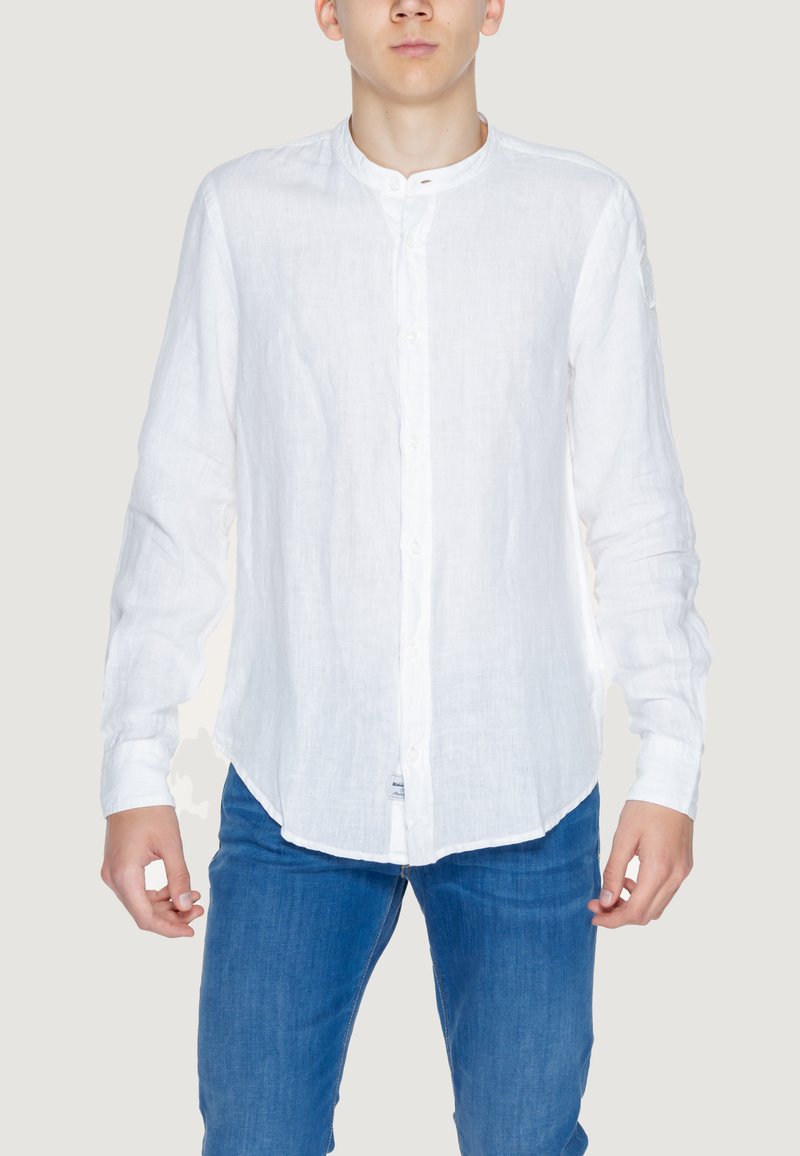 Camicia bianca in lino a maniche lunghe con colletto alla coreana e chiusura frontale con bottoni; presenta un orlo curvo e una texture leggermente trasparente.