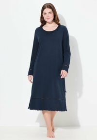 Granatowa nocna koszula z długim rękawem, wykonana z miękkiego materiału. Posiada dekolt w serek, koronkowe wykończenie na mankietach i u podstawy, oraz luźny krój.