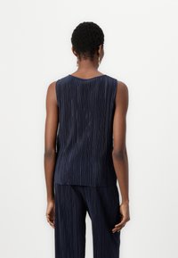 Navy blue sleeveless top with a pleated texture, round neckline, and a relaxed fit. Fabric drapes softly with subtle lines throughout.