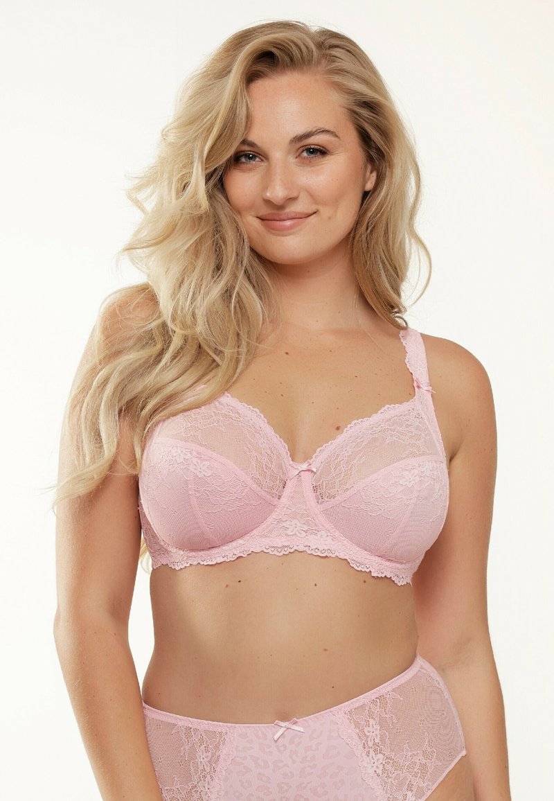 Roze kanten beha met doorzichtige delen, bloemenpatroon en een klein strikje in het midden. Verstelbare bandjes en beugels voor ondersteuning.