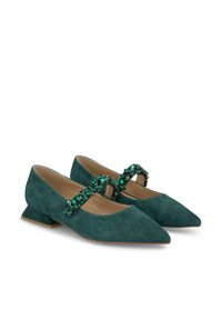 Scarpe verdi in suede con punta a punta e tacco a blocco basso, dotate di una fascia di gioielli sulla parte superiore del piede. Texture liscia e dettagli decorativi.
