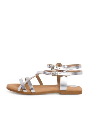 Srebrne metaliczne sandały na płaskiej podeszwie z dwoma paskami wokół kostki zapinanymi na sprzączki oraz miękką beżową wkładką.