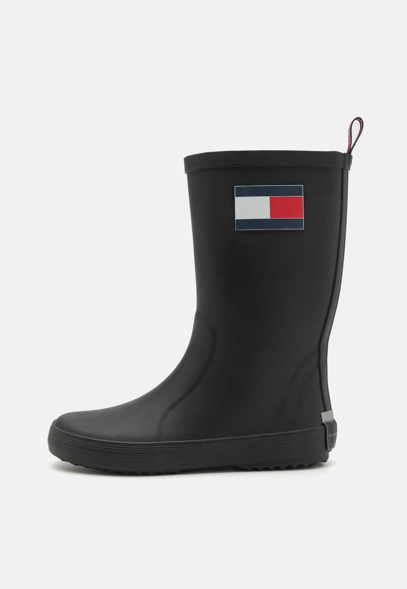 Botte de pluie en caoutchouc noir avec une finition lisse, présente un logo de drapeau coloré sur le côté et une semelle texturée pour une meilleure adhérence.