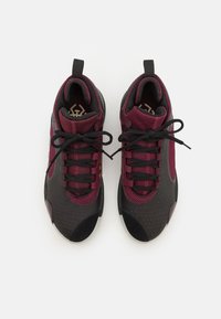Hoge sportieve schoenen met een bordeauxrode mesh bovenkant, zwarte accenten, platte zwarte veters en geperforeerde details op de teen.
