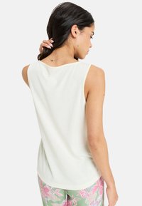 Lichtbeige mouwloze top met een ronde halslijn en een comfortabele pasvorm, met een soepele textuur en een subtiele zoom.
