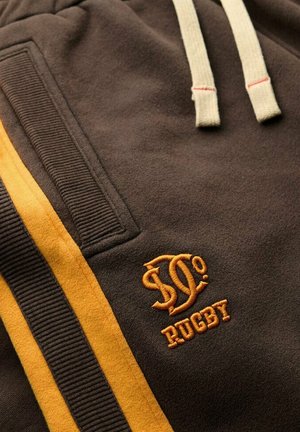 Brown sweatshirt with beige drawstrings, featuring an embroidered logo and "RUGBY" in orange. Side has vertical yellow stripes and ribbed texture.