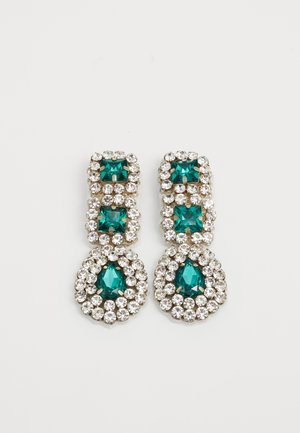 Hangende oorbellen met twee vierkante groene edelstenen boven een druppelvormige groene edelsteen, allemaal omringd door kleine heldere rhinestones op een witte achtergrond.