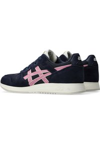 Námořnické modré semišové a síťované tenisky s růžovými akcenty a bílou podešví. Obsahuje logo ASICS, šněrování vpředu a zaoblený design špičky.
