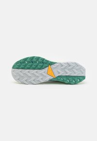 Suela de zapato que presenta material de goma, combinación de colores gris y verde, patrones texturizados y un acento triangular amarillo para tracción.