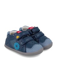 Zapatillas de cuero azul con correas de velcro, puntera de ante gris y suelas de goma. Presentan acentos de engranajes coloridos y un patrón geométrico.