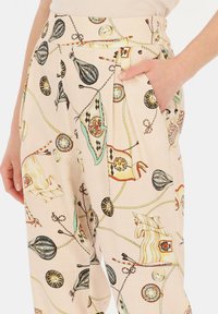 Jasnoróżowe spodnie z kolorowym nadrukiem motywów morskich i żeglarskich. Zawierają boczną kieszeń i plisowany krój.