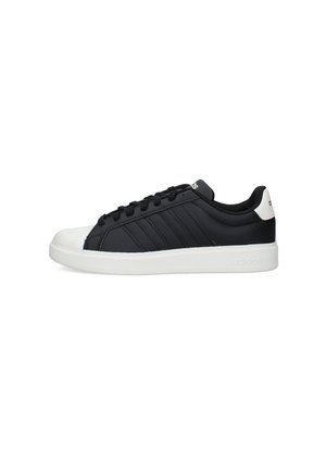 Scarpa da ginnastica Adidas bassa in bianco e nero con design con lacci, punta bianca, suola bianca e logo Adidas sul tallone e sulla linguetta.