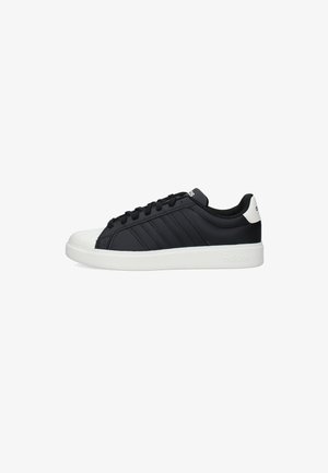 Scarpa da ginnastica Adidas bassa in bianco e nero con design con lacci, punta bianca, suola bianca e logo Adidas sul tallone e sulla linguetta.