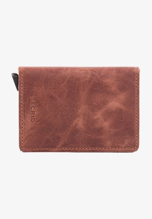 Braune Lederbörse mit strukturiertem Oberflächen, die ein schlichtes Design und ein eingraviertes Logo auf einer Seite aufweist. Kompakte rechteckige Form.