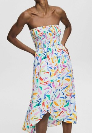 Strapless witte midi-jurk met kleurrijke abstracte penseelstreken, gerimpelde bustier en een wikkelrok op een donkerhuidige model.