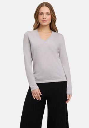 Top de manga larga en v de color gris claro con un cuerpo ajustado y textura acanalada, combinado con pantalones de pierna ancha negros. Diseño minimalista.