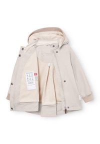 Svetlo bež otroška zimska jakna z flis podlogo, kapuco, rebrastimi manšetami, sprednjim zadrgo, pritisnimi gumbi in etiketo za nego tkanine znotraj.