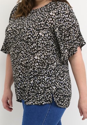 Zwarte blouse met korte mouwen en een bloemenpatroon bestaande uit kleine blauwe en beige bloemen. Losse, luchtige stof met zijsplitten aan de zoom.