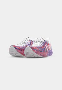 Running shoes with a vibrant, multicolored fabric upper in red, purple, and white. Features textured sole and mesh areas for breathability.