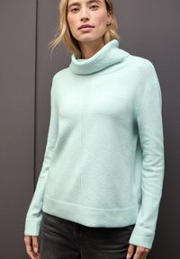 Jasnoturkuszowy sweter dzianinowy z żeberkowym kołnierzem, długimi rękawami i teksturowanym wykończeniem. Posiada prosty dół i subtelne detale szwów.