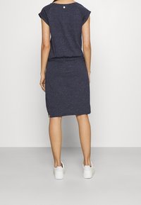 Klänning med marinrand i mjukt tyg, med avslappnad passform, korta ärmar och midjeband. En liten logotyp pryder fållen.