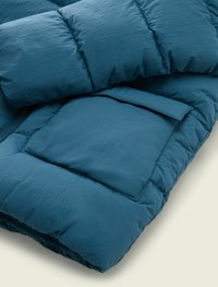 Teal puffer jacket with a quilted design, featuring a front pocket and textured fabric. Soft, lightweight, with elastic hem detail.