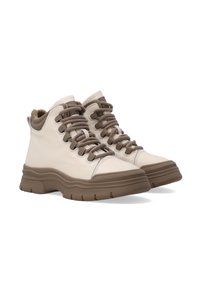 Beżowe sneakersy typu high-top z brązowymi akcentami, charakteryzujące się grubymi podeszwami, okrągłym kształtem oraz warstwowym systemem sznurowania.