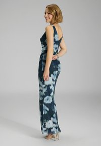 Abendkleid mit Blumenmuster in Dunkelblau mit grünen und weißen Akzenten. Ärmelloses Design, figurbetonter Schnitt und ein leichter Schleppe.