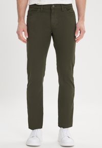 Olijfgroene broeken, slim fit, katoenmix, voorzakken en een enkele knoopsluiting, gecombineerd met witte sneakers.