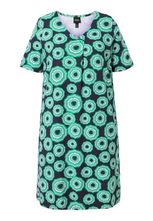 Kratší šaty délky ke kolenům s geometrickým vzorem kruhů v zelené, bílé a černé na tmavém pozadí.