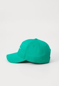 Grønn bomull baseball caps med buet skjerm, seks-panel design og broderte detaljer foran. Glatt tekstur, uhåndtert passform.