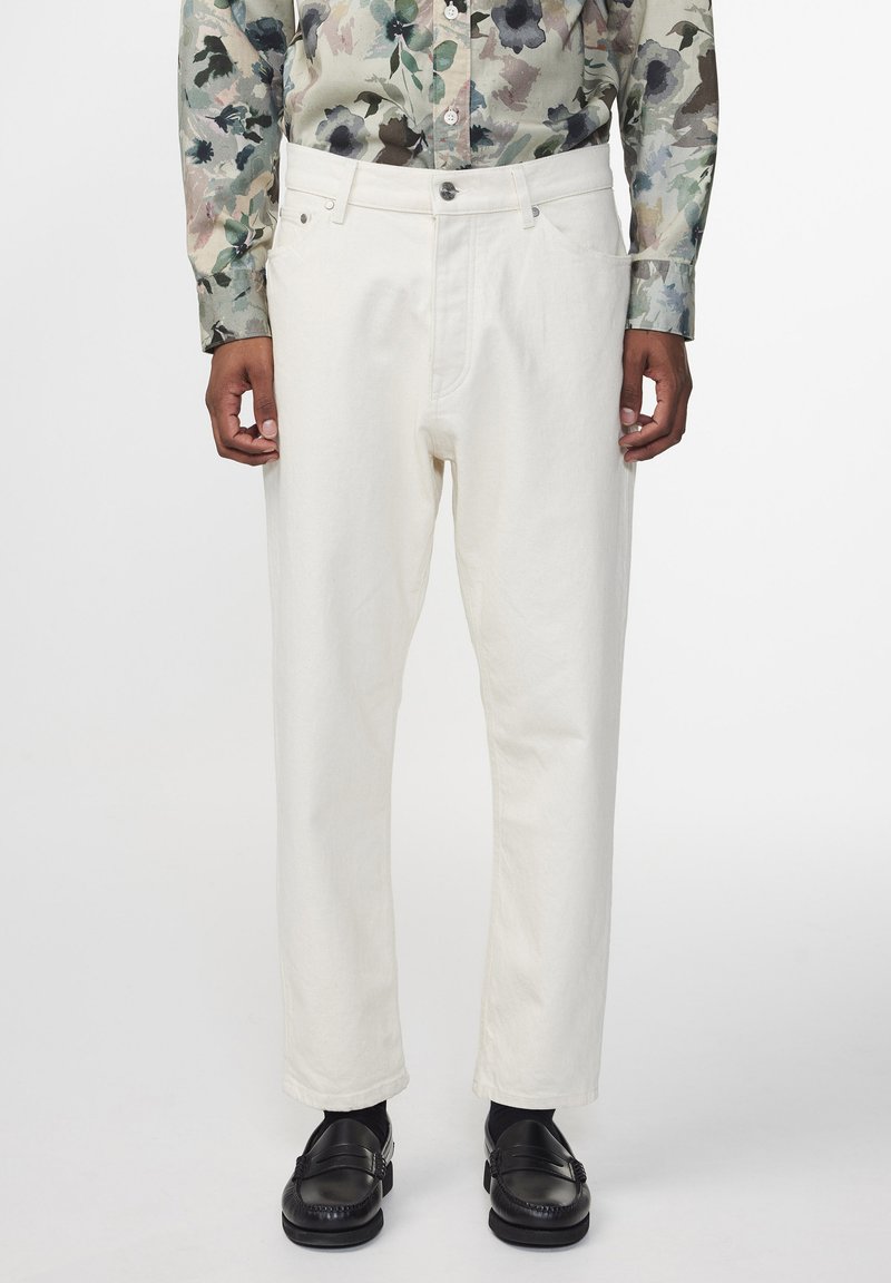 Pantalons blancs ample en mélange de coton avec une coupe droite ; dotés de poches avant et d'une fermeture à bouton.