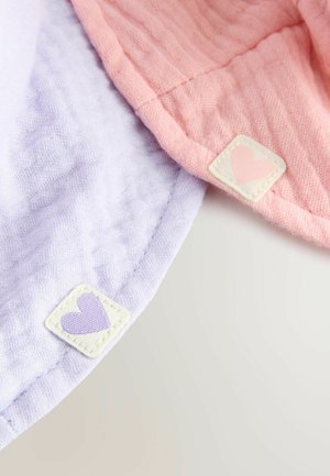 Deux morceaux de tissu doux et texturé, en lavande et rose, chacun avec une étiquette carrée présentant un motif en forme de cœur. Bords soigneusement ourlés.