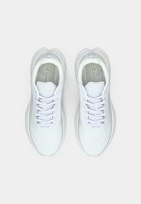 Λευκά αθλητικά παπούτσια με άνω μέρος από δίχτυ, στρογγυλή μύτη, επίπεδη σόλα και σχέδιο με κορδόνια. Το εσωτερικό διαθέτει εσωτερικό πάτο με μοτίβο.