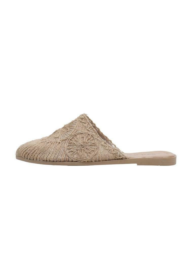 Mule beige tissé à enfiler avec surface texturée, présentant un motif floral et une semelle plate. Pas de talon ni de design à l'arrière fermé.