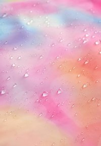 Abstrakcyjny materiał tekstylny z gradientem różowych, fioletowych i pomarańczowych odcieni, z kroplami wody na gładkiej, błyszczącej powierzchni.