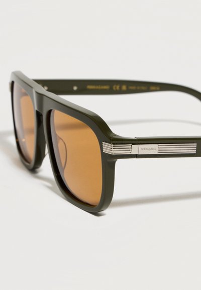 Ορθογώνια σκουρόχρωμα πράσινα γυαλιά ηλίου με καφέ φακούς και ασημί ριγέ διακοσμητικά στα πλαϊνά, με το λογότυπο Ferragamo.