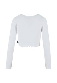 Vit, figurnära långärmad crop top med rund halsringning, ribbad textur och vågig nederkant. Enkelt design utan synlig hårdvara.