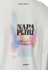 Weißes Baumwoll-T-Shirt mit schwarzem Text "SLOW DOWN." auf der Vorderseite und "NAPA PIJRI" in fetten schwarzen Buchstaben auf der Rückseite, dazu ein farbenfrohes Verlaufsdesign und der Text "REFLECT."