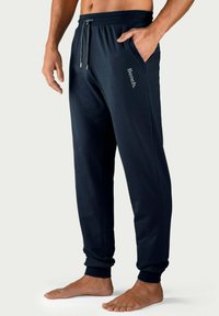 Marineblaue Jogginghose mit einem elastischen Bund, Kordelzug, Seitentaschen und Bündchen an den Knöcheln. Mit einem schlichten, grauen "Bench"-Logo.