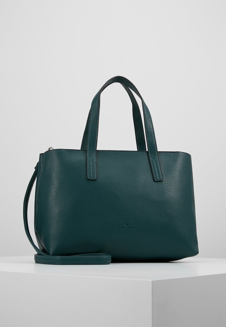 Sac à main en cuir vert foncé texturé avec deux poignées et une bandoulière amovible, présenté sur une surface blanche.