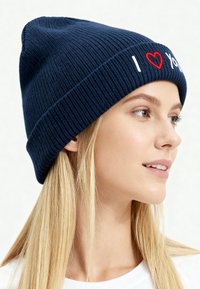 Cappello lavorato a maglia blu navy con texture a costine, caratterizzato dal testo "I ❤️ You" ricamato in bianco e rosso sul risvolto.
