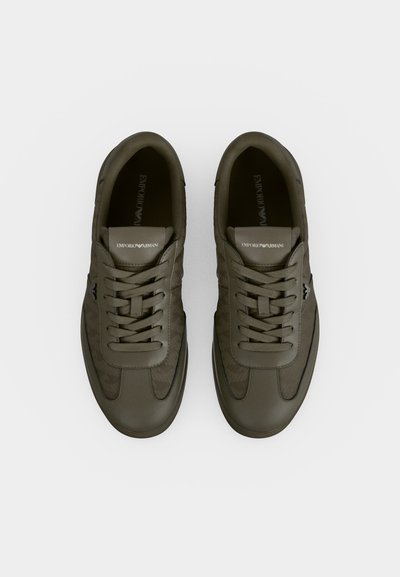 Ζευγάρι χαμηλών sneakers σε ελιά πράσινο με κορδόνια, με τη σήμανση Emporio Armani στη γλώσσα, εμφανιζόμενα από πάνω σε λευκό φόντο.