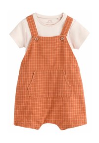 Baby overalls i orange med et rutemønster, har justerbare skulderstropper, en stor frontlomme og en hvid bomulds t-shirt under.