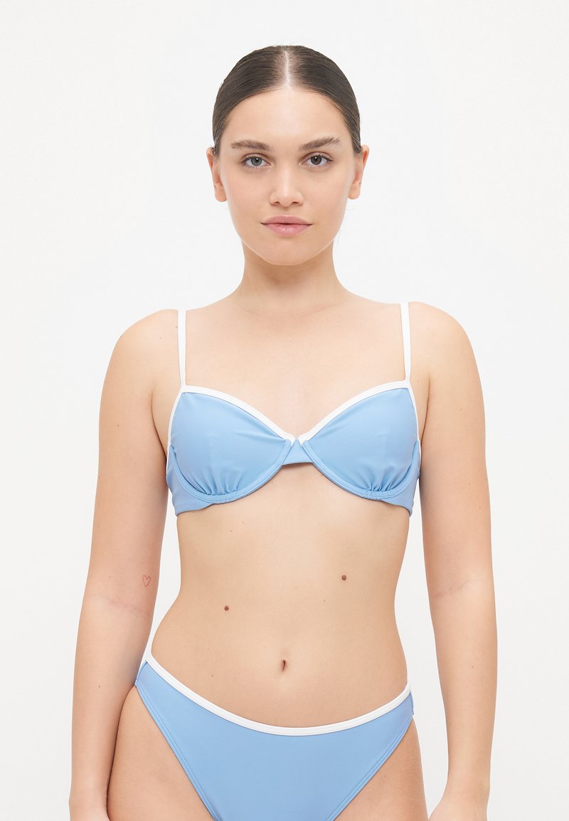Blå bikinitopp med hvit kant; underwire-design, tynne justerbare stropper, glatt tekstur, kombinert med matchende bikini-bunner.