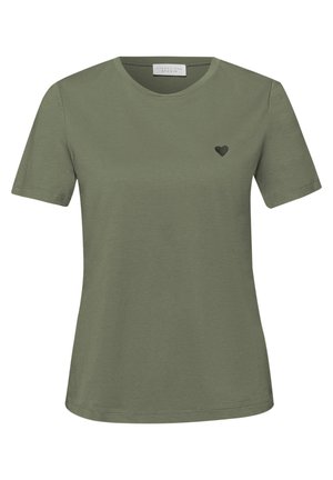 T-shirt da donna a maniche corte color verde oliva con scollo a girocollo e piccolo emblema a cuore nero sul lato sinistro del petto.