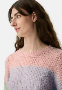 Multicolor Pullover mit einem pinken und lavendelfarbenen Design, strukturiertem Strick, Rundhalsausschnitt und weichem, flauschigem Material.